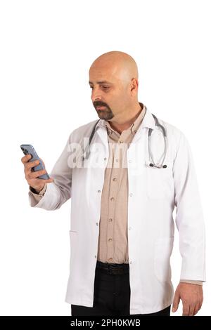 Porträt eines Glatzarztes mittleren Alters mit Hilfe der medizinischen App. Männlicher Arzt mit Smartphone auf isoliertem weißem Hintergrund. Ich halte das Handy. Stockfoto