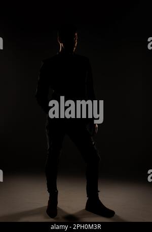 Attraktiver Mann, der sich im Studio vor der Kamera mit einem leicht geneigten Winkel posiert Stockfoto