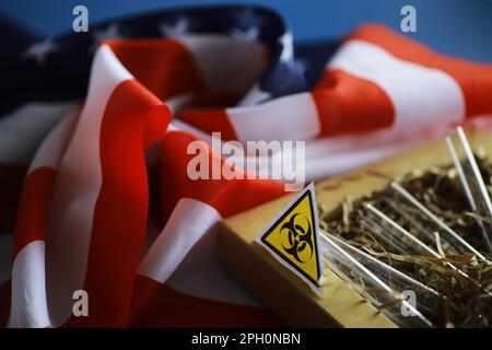 Amerikanische Flagge und Schild für biologische Gefahrenstoffe. Das Konzept amerikanischer Biolabsforschungszentren. Stockfoto