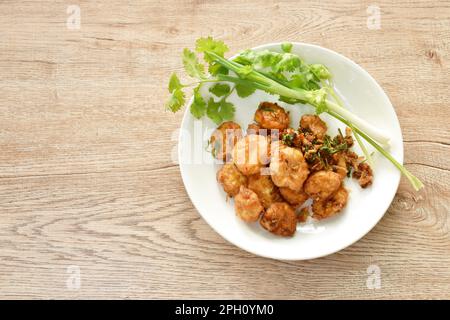 Knusprig gefülltes Tofu-Mehl Dressing Knoblauch und Pfeffer mit Frühlingszwiebeln und Petersilie auf dem Teller Stockfoto