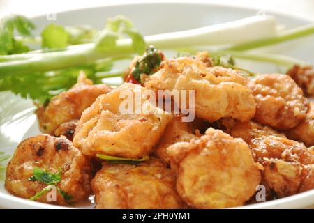 Knusprig gefülltes Tofu-Mehl Dressing Knoblauch und Pfeffer mit Frühlingszwiebeln und Petersilie auf dem Teller Stockfoto