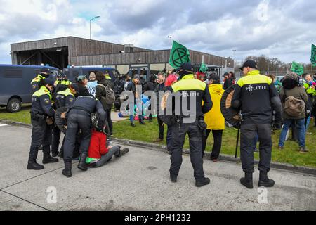 Eindhoven, Niederlande. 25. März 2023. Klimaschutzaktivisten protestieren am Flughafen Eindhoven gegen Luft- und Lärmbelästigung und Gesundheitsschäden.Sie behaupten auch, dass die Naturgenehmigungen nicht in Ordnung seien.Eine Gruppe von Demonstranten durchbrach einen Zaun, wurde aber von Police Credit gestoppt: Pmvfoto/Alamy Live News Stockfoto