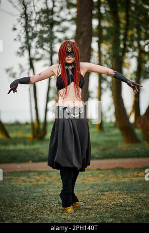 Mythologisches Tanzmädchen Faun auf grünem Rasen im öffentlichen Park Kunstveranstaltung im Freien mit mythologischer Atmosphäre. Ein Mädchen im Bild einer mythischen Kreatur Stockfoto