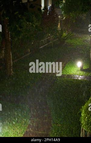 Ein heftiger tropischer Regenschauer in der Wohnung in der Nacht. Stockfoto