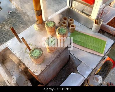 Putu-Kuchen ist eine Art traditioneller indonesischer Imbiss in Form eines mit Palmzucker gefüllten Torts, bedeckt mit geriebener Kokosnuss und grobem Getreidereis Stockfoto