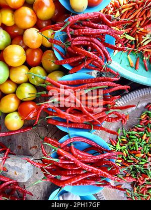 Verschiedene Gemüsesorten wie Chilis, Tomaten, rote Chilis, Bohnen werden auf dem Markt in Indonesien so angerichtet. Stockfoto