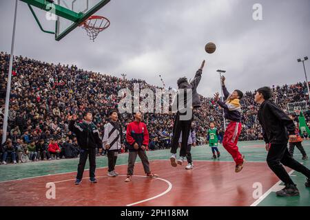 (230325) -- TAIJIANG, 25. März 2023 (Xinhua) -- Kinder spielen Basketball in Taipan Village, Taijiang County, Provinz Guizhou im Südwesten Chinas, 25. März 2023. „Village Basketball Association“ oder „Village BA“ ist ein Basketballturnier mit Grassroot im Dorf Taipan. Diese von Einheimischen organisierte Veranstaltung hat im Laufe der Jahre an Popularität gewonnen und zieht eine große Menge von Zuschauern und Teilnehmern gleichermaßen an. Das Turnier zeigt die Leidenschaft und das Können von Basketballspielern aus ländlichen Gebieten, während sie auf dem Platz gegeneinander antreten und ihre Teamarbeit demonstrieren. (Xinhua/Wu Zhuang) Stockfoto