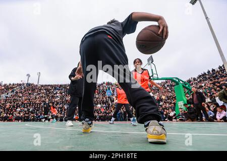 (230325) -- TAIJIANG, 25. März 2023 (Xinhua) -- Kinder spielen Basketball in Taipan Village, Taijiang County, Provinz Guizhou im Südwesten Chinas, 25. März 2023. „Village Basketball Association“ oder „Village BA“ ist ein Basketballturnier mit Grassroot im Dorf Taipan. Diese von Einheimischen organisierte Veranstaltung hat im Laufe der Jahre an Popularität gewonnen und zieht eine große Menge von Zuschauern und Teilnehmern gleichermaßen an. Das Turnier zeigt die Leidenschaft und das Können von Basketballspielern aus ländlichen Gebieten, während sie auf dem Platz gegeneinander antreten und ihre Teamarbeit demonstrieren. (Xinhua/Ou Dongqu) Stockfoto