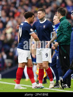 Schottlands Che Adams (links) wird während des Qualifikationsspiels der UEFA Euro 2024 Group A im Hampden Park, Glasgow, durch den Teamkollegen Lyndon Dykes ersetzt. Foto: Samstag, 25. März 2023. Stockfoto