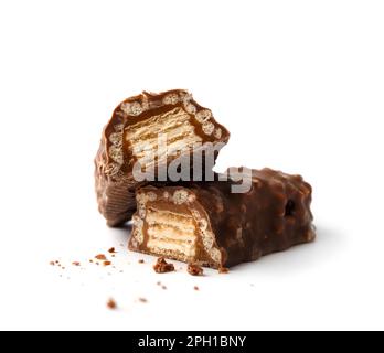 Zwei Hälften eines Schokoladenriegels gefüllt mit knusprigen Waffeln und Karamell isoliert auf weißem Hintergrund. Knusprige Schokoladenriegel. Stockfoto