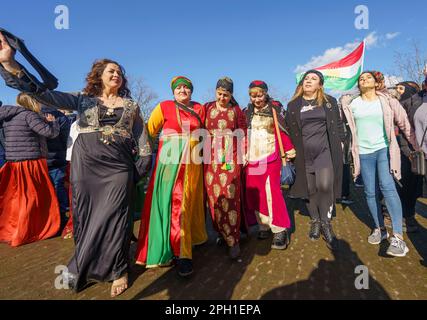 25. März 2023, Hessen, Frankfurt/Main: Frauen in traditionellen Kleidern tanzen bei der zentralen Feier des kurdischen Neujahrs „Newroz“ zu traditioneller Musik. Tausende von Menschen aus ganz Deutschland haben sich im Rebstockpark versammelt, um das kurdische Neujahr „Newroz“ zu feiern. Foto: Andreas Arnold/dpa Stockfoto