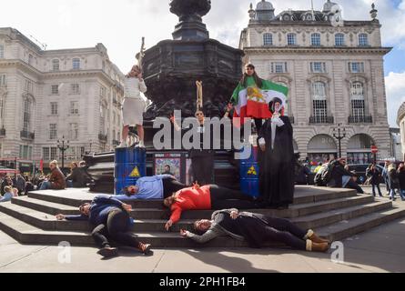 London, Großbritannien. 25. März 2023 Iranische Demonstranten inszenieren einen "Tod". Iranische und ukrainische Frauen organisierten einen gemeinsamen Protest im Piccadilly Circus und forderten Freiheit im Iran und ein Ende der russischen Angriffe in der Ukraine. Kredit: Vuk Valcic/Alamy Live News Stockfoto