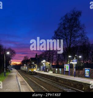 Der Zug der Northern Rail Klasse 150 DMU fährt zum kleinen Bahnhof Chapel-en-Le-Frith, Derbyshire, mit 2 Bahnhöfen und rotem Sonnenuntergang Stockfoto