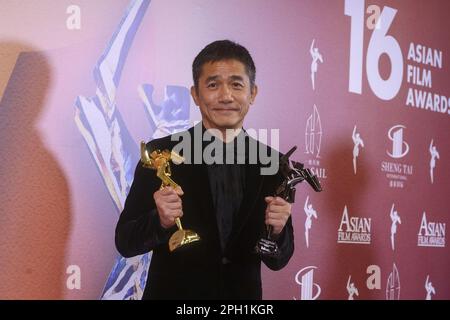 Tony Leung Chiu-wai posiert mit seiner Auszeichnung, nachdem er bei den Asian Film Awards 16. im Hong Kong Palace Museum in Hongkong am 12. März 23 den besten Schauspieler mit dem Titel „Where the Wind Blows“ gewonnen hat. SCMP/Dickson Lee Stockfoto