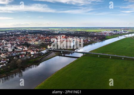 Blick auf die elbe in der Nähe von torgau. Die Altstadt von torgau ist am linken Ufer zu sehen. Im Hintergrund ein Industriegebiet. Die elbbrücke ist in der Stockfoto