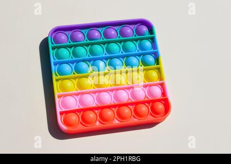 Einfacher Dimple. Anti-Stress-Pop-it-Spielzeug. Sensorisches Fidget auf weißem Hintergrund isoliert. Neue trendige bunte Silikon-Spielzeug für Kinder.Draufsicht. Speicherplatz kopieren. De Stockfoto