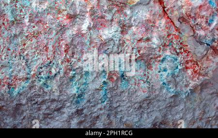 Ein großer Stein mit Farbspritzern sorgt für eine schöne Textur oder einen Hintergrund mit viel Platz für Kopien. Der weiche Fokus eignet sich gut für Text oder Grafiken. Stockfoto