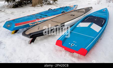 Fort Collins, CO, USA - 25. März 2023: Vorbereitung auf eine Paddel- und Rennsaison - drei Stehpaddleboards von Steuerboard und SIC Maui in einem Backyar Stockfoto