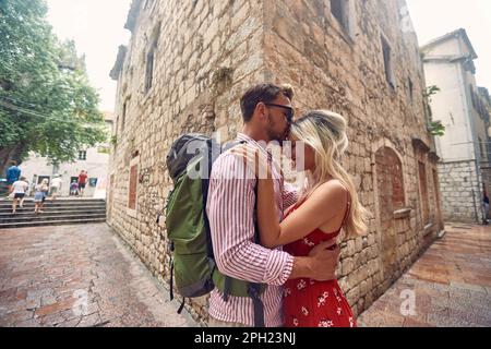 Ein Touristenpaar, das im Sommer auf der Straße kuschelt. Alte Gebäude. Europäische Stadt. Junge Leute im Urlaub. Date, Liebe, Feiertagskonzept. Stockfoto