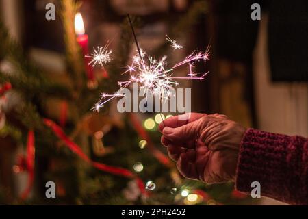 Hand mit einem Weihnachtsfunkler Stockfoto