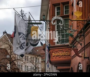 BASEL, SCHWEIZ - 27. FEBRUAR 2023: Kunstvolle Schilder und Flaggen in der Altstadt Stockfoto