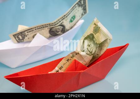 Papier wird mit US- und chinesischen Banknoten geliefert, ein Dollar und ein Yuan, Wirtschaftskrieg, Geschäfts- und Finanzkonzept, Nahaufnahme Stockfoto