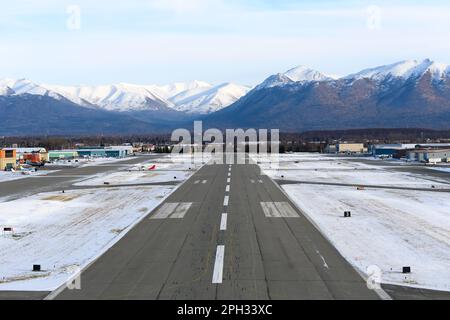 Merrill Field Landebahn mit Bergen dahinter. Merrill Field Airport in Anchorage, hauptsächlich für die allgemeine Luftfahrt genutzt. Stockfoto