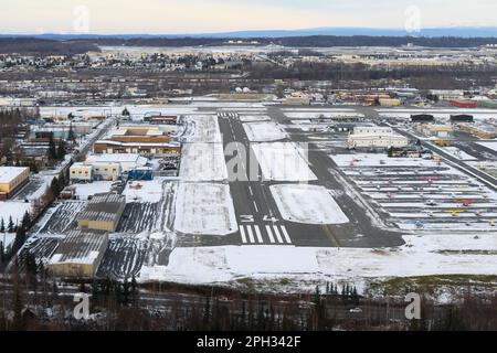 Merrill Field Flughafen in Anchorage, hauptsächlich für die allgemeine Luftfahrt genutzt. Merrill Feldbahn mit Bergen dahinter. Stockfoto