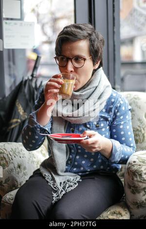 Ein Mädchen trinkt Kaffee in einem Café Stockfoto