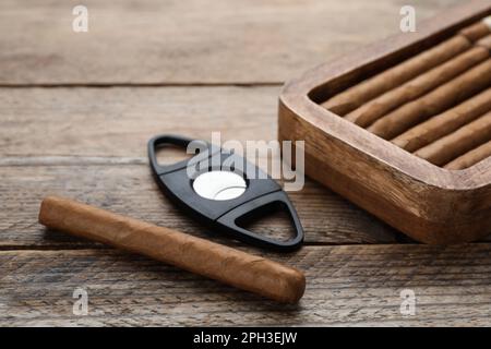 Zigarren und Schneidemaschine auf Holztisch, Nahaufnahme Stockfoto