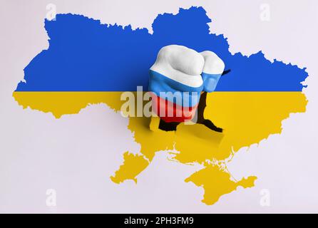 Russische Aggression gegen die Ukraine. Ein Mann durchbricht die Karte der Ukraine mit einer Faust in den Farben der russischen Flagge Stockfoto