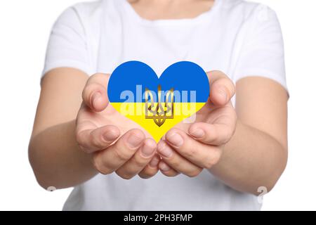 Beenden Sie den Krieg in der Ukraine. Frau mit herzförmigem Symbol in den Farben der ukrainischen Flagge und Tryzub in den Händen auf weißem Hintergrund, Nahaufnahme Stockfoto