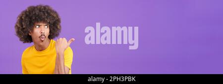 Ein afrikanischer Mann, der überrascht zur Seite zeigt Stockfoto