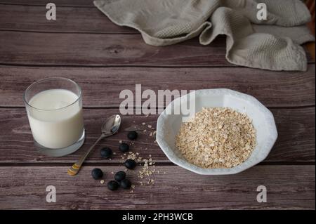 Haferflocken mit Blaubeeren und Milch auf Holzhintergrund Stockfoto