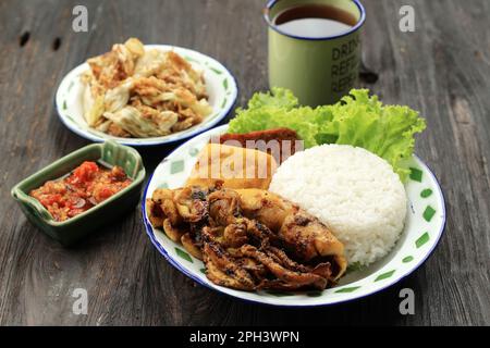 Reis mit gegrilltem gerösteten Tintenfisch, serviert mit scharfem Sambal und Kol Goreng, Penyetan-Gericht Stockfoto