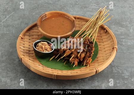 Sate Padang. Scharfer Rindsatay aus Padang, West Sumatra. Serviert mit scharfer Curry-Sauce und Lontong oder Ketupat. Stockfoto