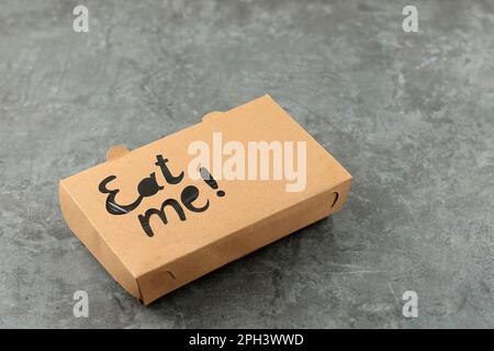 Lebensmittelverpackung aus Papier für Mahlzeiten für unterwegs mit Eat Me Stamp auf der Oberseite Stockfoto