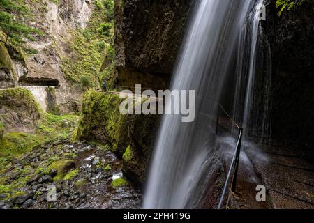 Wanderer in Levada Nova, Nova Wasserfall und Moinho in einer Schlucht, lange Exposition, Ponta do Sol, Madeira, Portugal Stockfoto