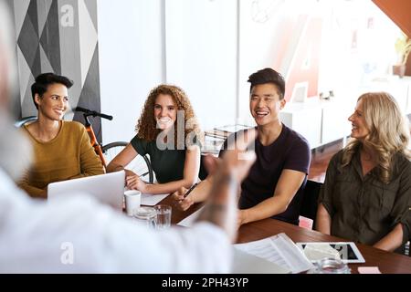 Sprechen Sie mit seinen Mitarbeitern. Rückansicht eines erwachsenen Geschäftsmannes, der seinen Kollegen in einem Büro eine Präsentation hält. Stockfoto