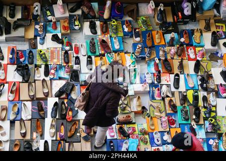 Barcelona, Spanien - 02. März 2016: Frau, die auf einem Flohmarkt im Mercat dels Encants in Barcelona durch die große Auswahl an Schuhen bummelt Stockfoto