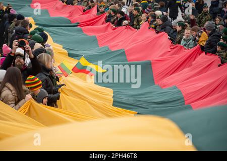 Vilnius Litauen - März 11 2022: Riesige litauische Flagge entlang der Gedimino Avenue in Vilnius, die von Menschen mit litauischen und ukrainischen Flaggen getragen wird Stockfoto