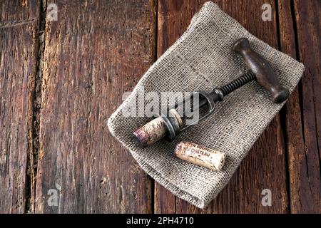 kork und Korkenzieher auf rustikalem Holzhintergrund Stockfoto