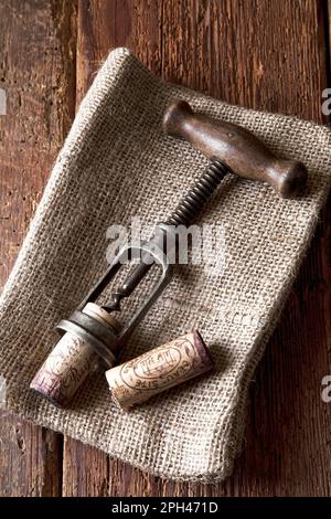 kork und Korkenzieher auf rustikalem Holzhintergrund Stockfoto