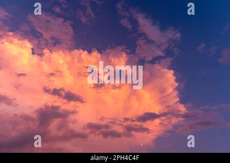 Purpurfarbener Himmel in der Dämmerung am Abend, dunkler Hintergrund am Himmel. Farbenfroher Himmel. Abendhintergrund. Dramatischer Sonnenaufgang, Sonnenuntergang, rosa violett blauer Himmel mit Cirru Stockfoto