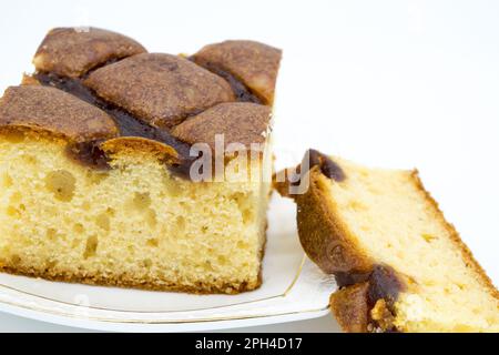 Festlicher Kuchen mit Marmelade auf weißem Teller in Nahaufnahme auf weißem Hintergrund Stockfoto