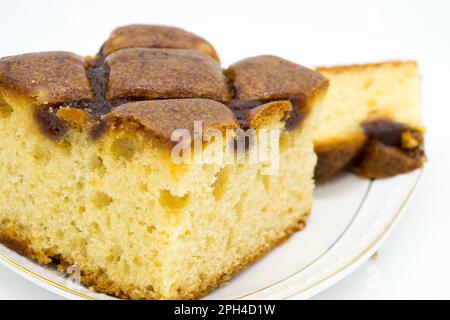 Festlicher Kuchen mit Marmelade auf weißem Teller in Nahaufnahme auf weißem Hintergrund Stockfoto