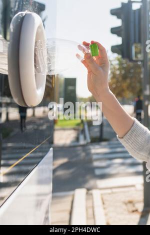 Eine Frau benutzt einen Selbstbedienungsautomaten, um gebrauchte Plastikflaschen und Dosen auf einer Straße in der Stadt zu erhalten. Hochwertiges Foto Stockfoto