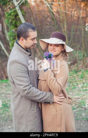 Der Mann schenkt seiner Frau Blumen im Herbstpark Stockfoto