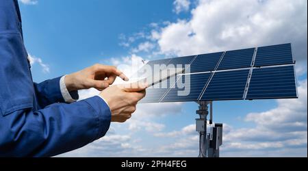 Ingenieur mit Tablet-Computer vor dem Hintergrund eines Solarenergiekraftwerks. Hochwertiges Foto Stockfoto