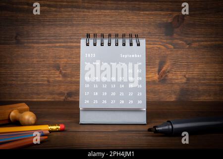 2023. SEPTEMBER. Kalender aus schwarzem Papier auf einem Holztisch. Zeitplanung, Tageszählung und Feiertage. Stockfoto